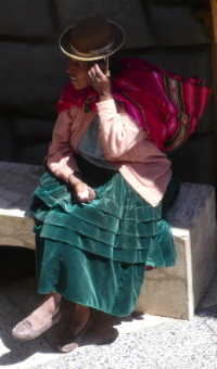An Andean woman in Puno using her mobile